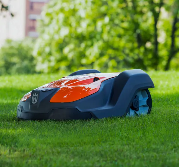Autocut smart robotic lawn mower cutting grass in a connected garden as part of an outdoor smart home automation system.