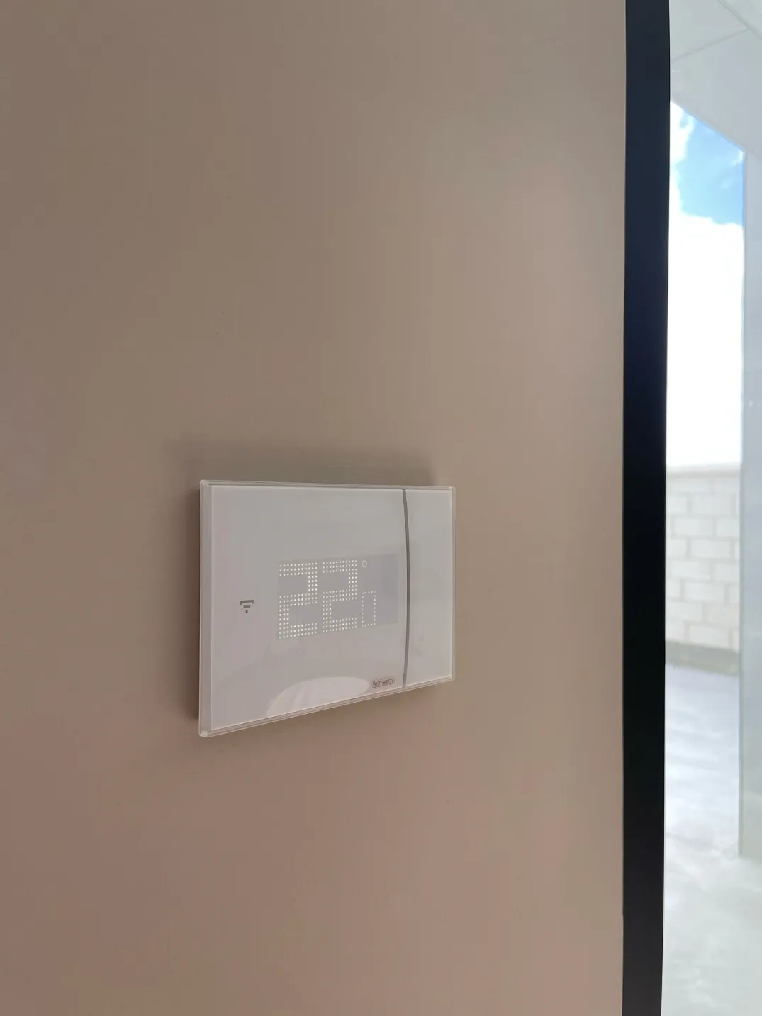 Smart glass touchscreen thermostat controlling home heating as part of a smart home system.