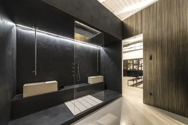 Luxury smart home bathroom with dark microcement walls, integrated lighting, and concealed controls