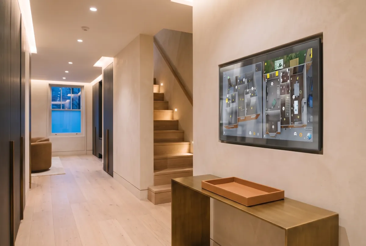 Wall-mounted touch panel showing the SH-Pro 3D floor plan digital twin of a London residence